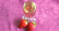 Overhead view of AbFab cocktail in champagne flute with strawberries