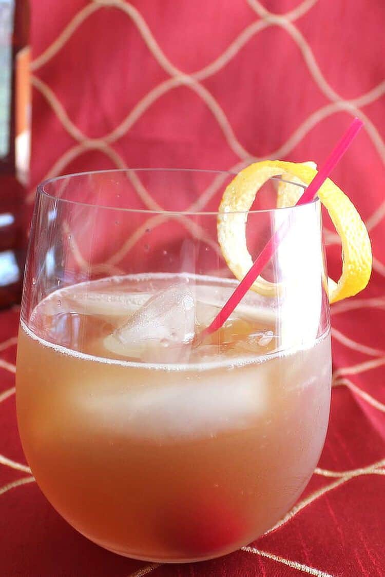 Amaretto Sour cocktail with lemon twist and cherry