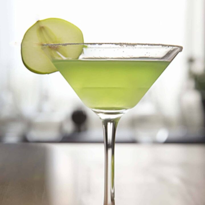 Appletini cocktail with apple slice garnish