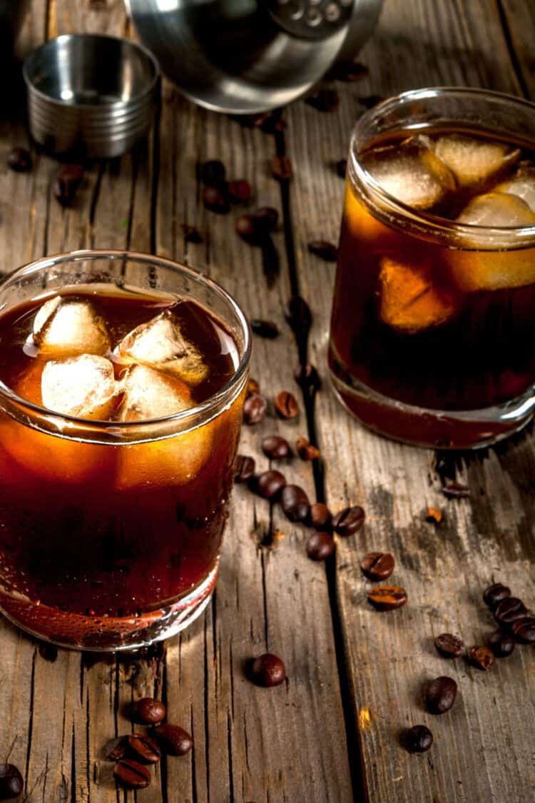 Two Black Russian drinks on table with coffee beans