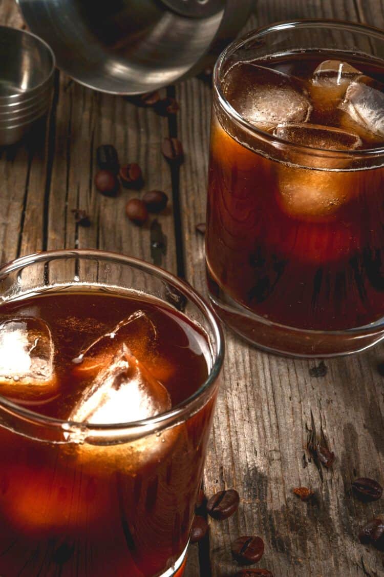 Closeup view of Two Black Russian drinks on a table with coffee beans