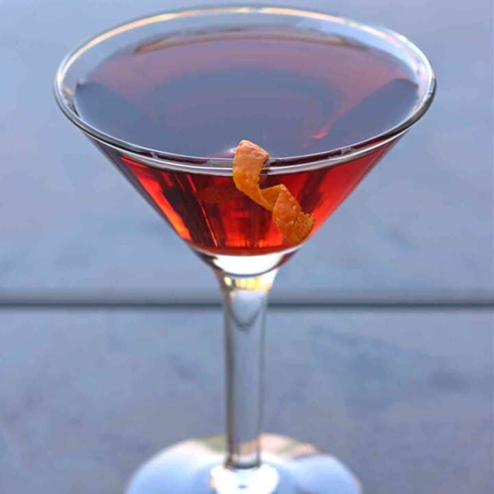 Boulevardier drink with orange twist on patio table