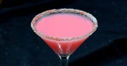 Bright pink Candy Cane Cocktail with candy cane rim