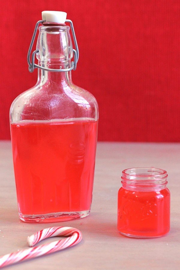 Candy Cane Vodka infusion in flask and shot glass with candy cane on table