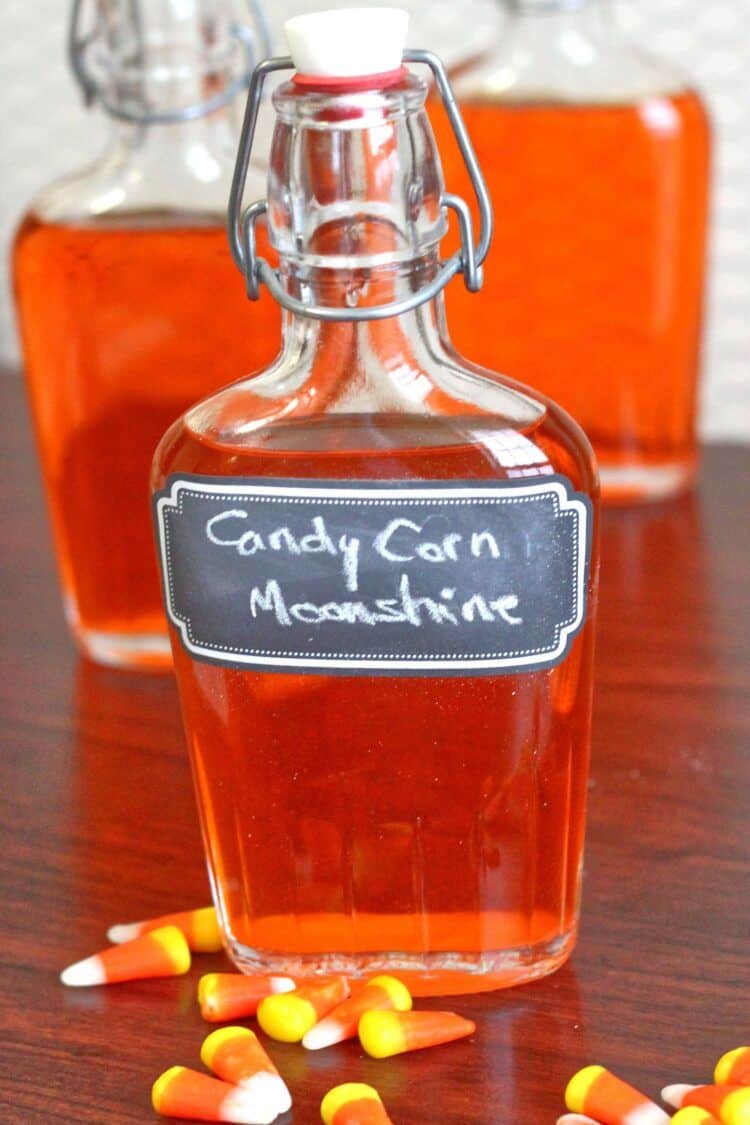 Candy Corn Moonshine infusion in flasks with labels