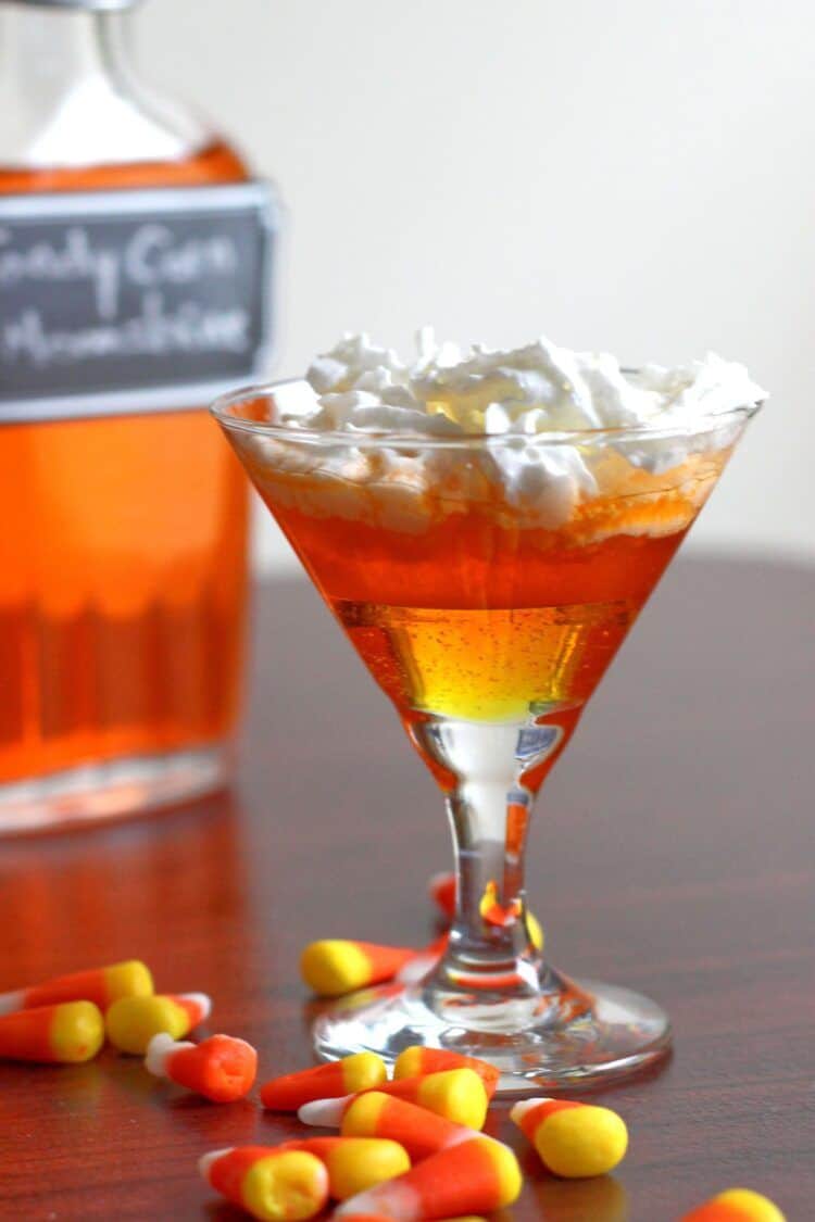 This Candy Corn Moonshine infusion is loads of fun, especially for tailgating and Halloween parties. This easy recipe also works with vodka or rum if you prefer. #candycornmoonshine #candyvodka #candycorn #halloweendrinks #tailgatingdrinks #candycornvodka