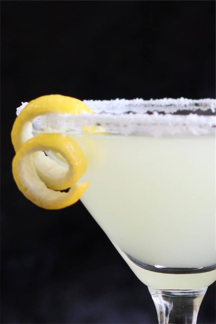 Closeup of yellow drink with lemon garnish