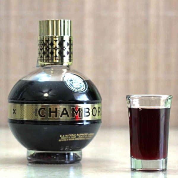 Bottle of Chambord next to shot glass of same
