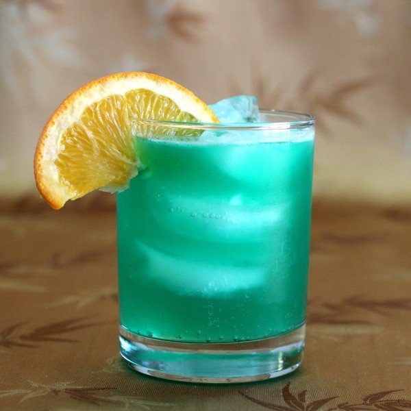 Bright teal Chameleon drink with orange slice