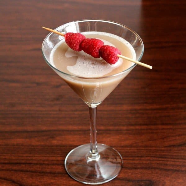 Chocolate Raspberry Martini on wood bar with raspberry garnish