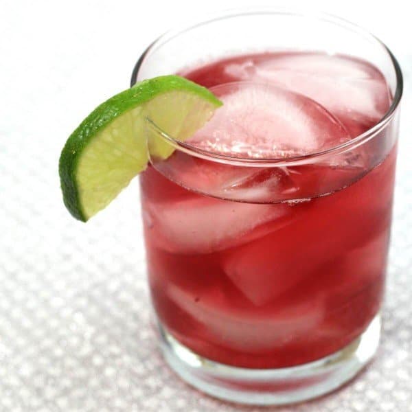 Closeup view of Cranberry Gin cocktail with lime wedge