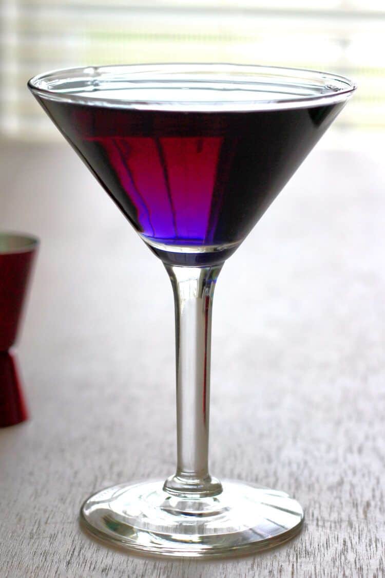 Deep purple colored creme de violette cocktail in martini glass