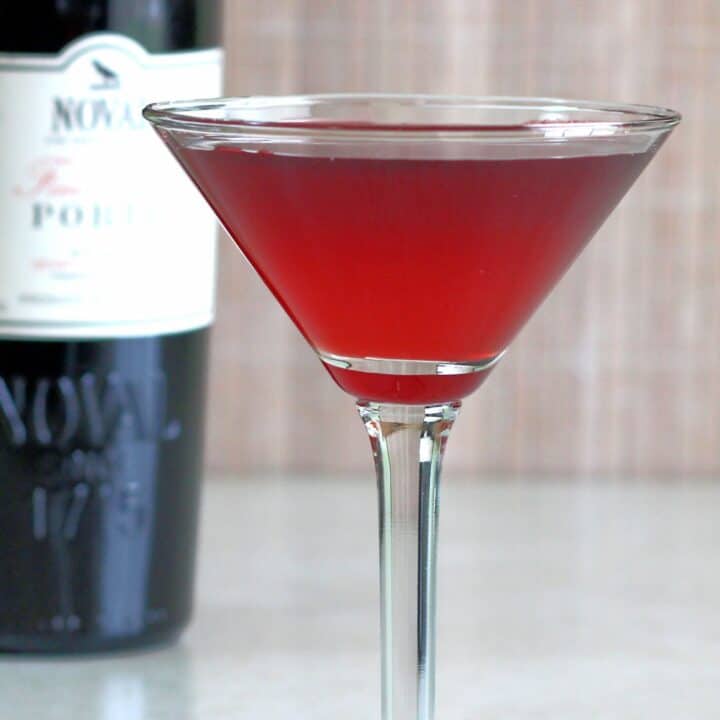 Crimson Cocktail in front of bottle of port