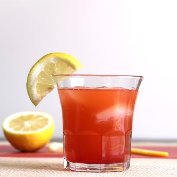 Full-length view of Crystal Cranberry drink with lemons on cutting board