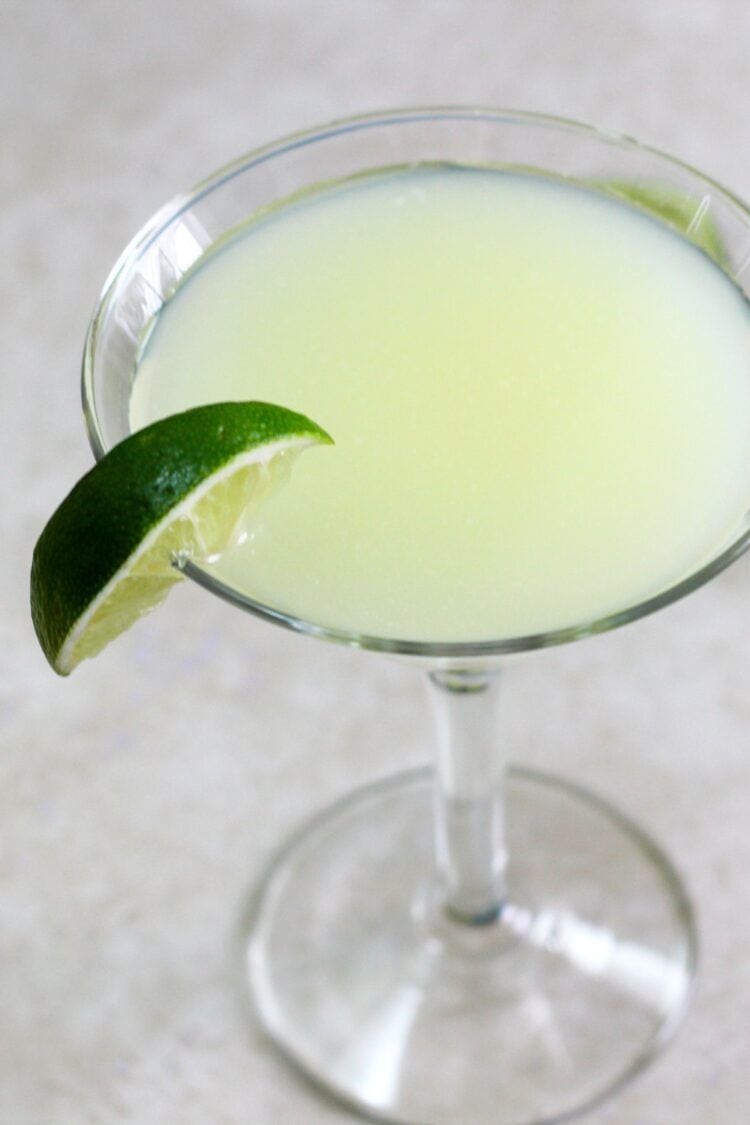 Closeup view of Daiquiri cocktail with lime on table