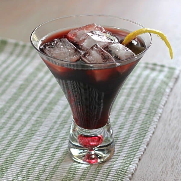 Angled view of Desiree Cocktail in martini glass with ice with lemon twist