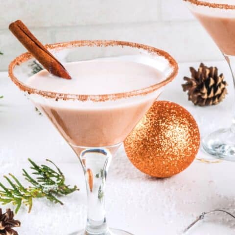 Eggnog Martini drink surrounded by Christmas decor