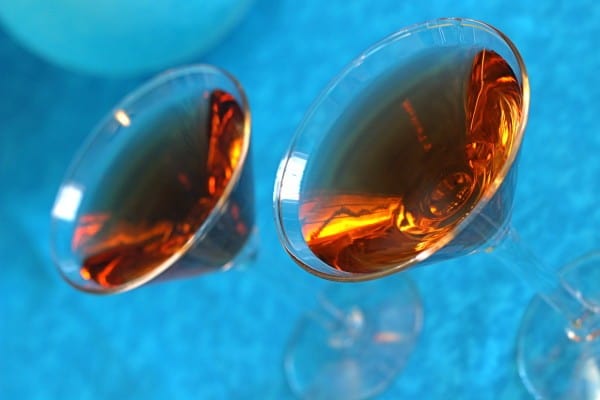 Tilted angle view of Ethel Duffy cocktails against blue background