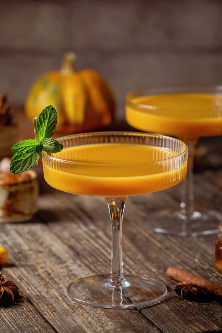 Orange cocktails on table with fall gourds