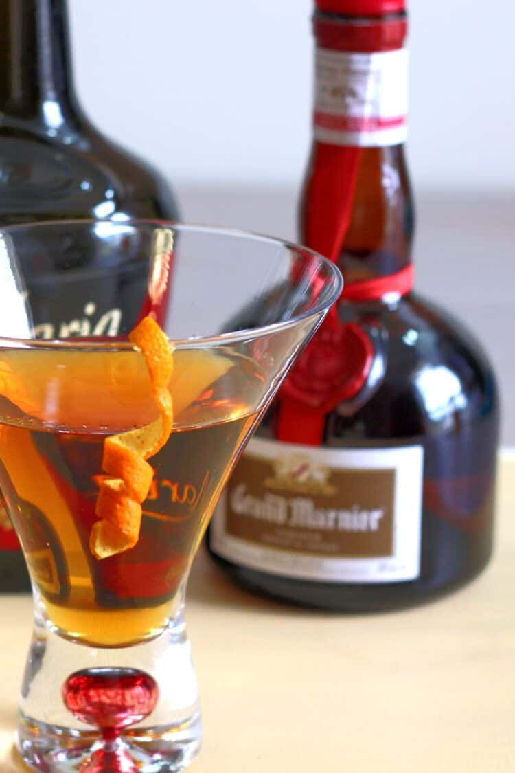 Bottle of Grand Marnier behind orange cocktail