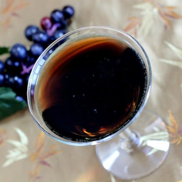 Overhead view of Grape Russian Tea drink in cocktail glass next to grapes