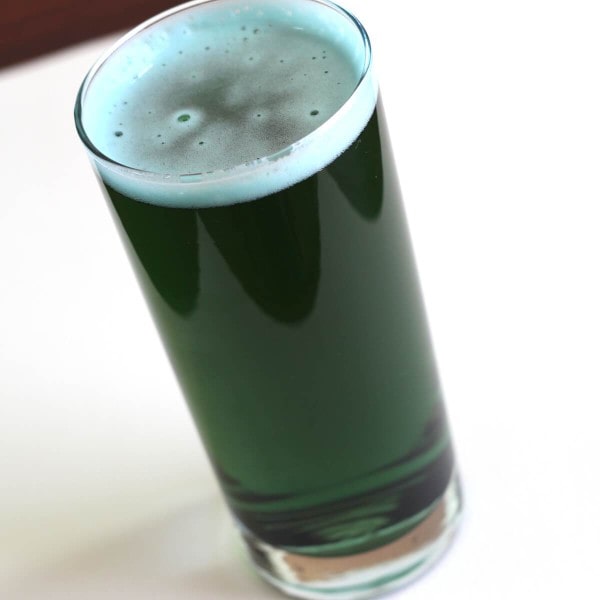 Glass of dark green beer with blue tinge
