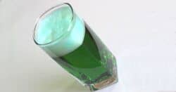 Glass of green beer at tilted angle