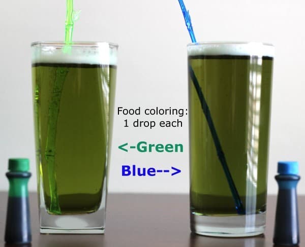 Two glasses of olive green beer, each with one drop of green or blue food coloring