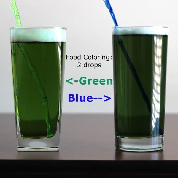 Two glasses of medium green beer, each with two drops of green or blue food coloring