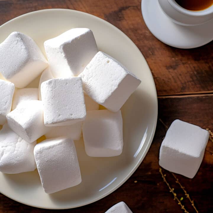 Homemade marshmallows on white plate on wooden table