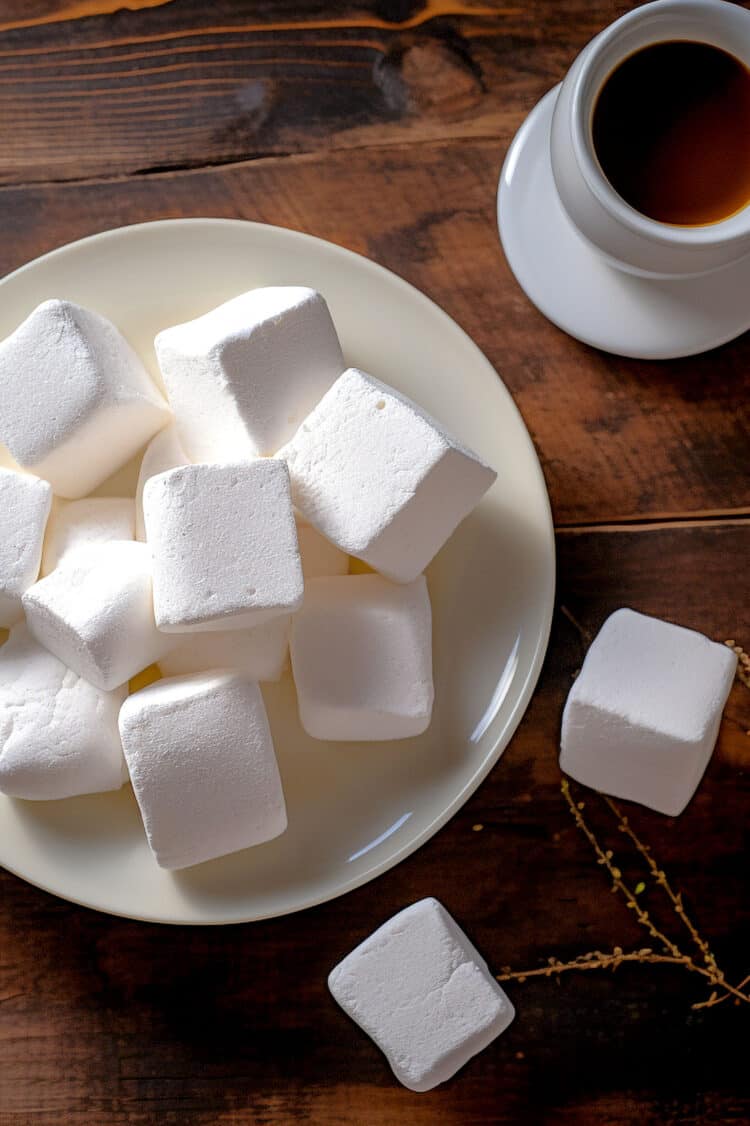 Homemade marshmallows on white plate on wooden table