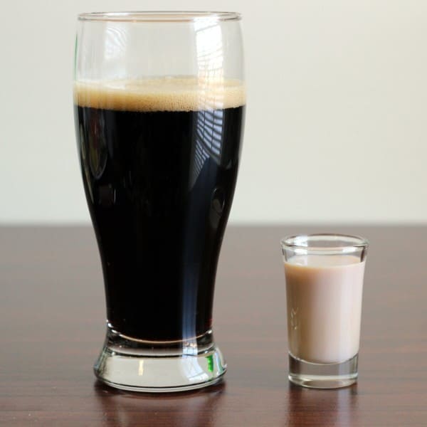 Full-length view of Irish Car Bomb drink in Pilsner glass next to shot of Baileys