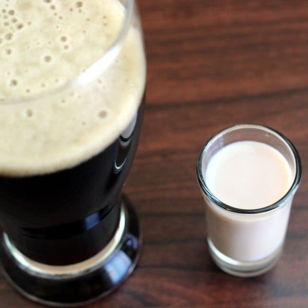 Overhead view of Irish Car Bomb drink in Pilsner glass beside shot of Baileys