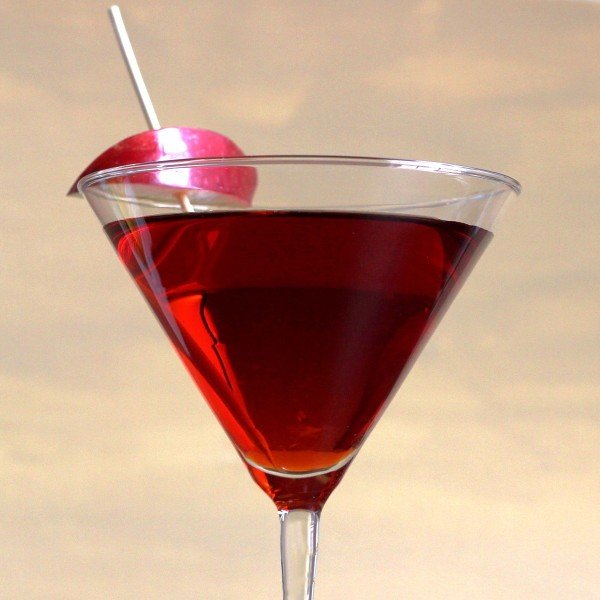 Closeup view of Jack Rose Cocktail beside apple