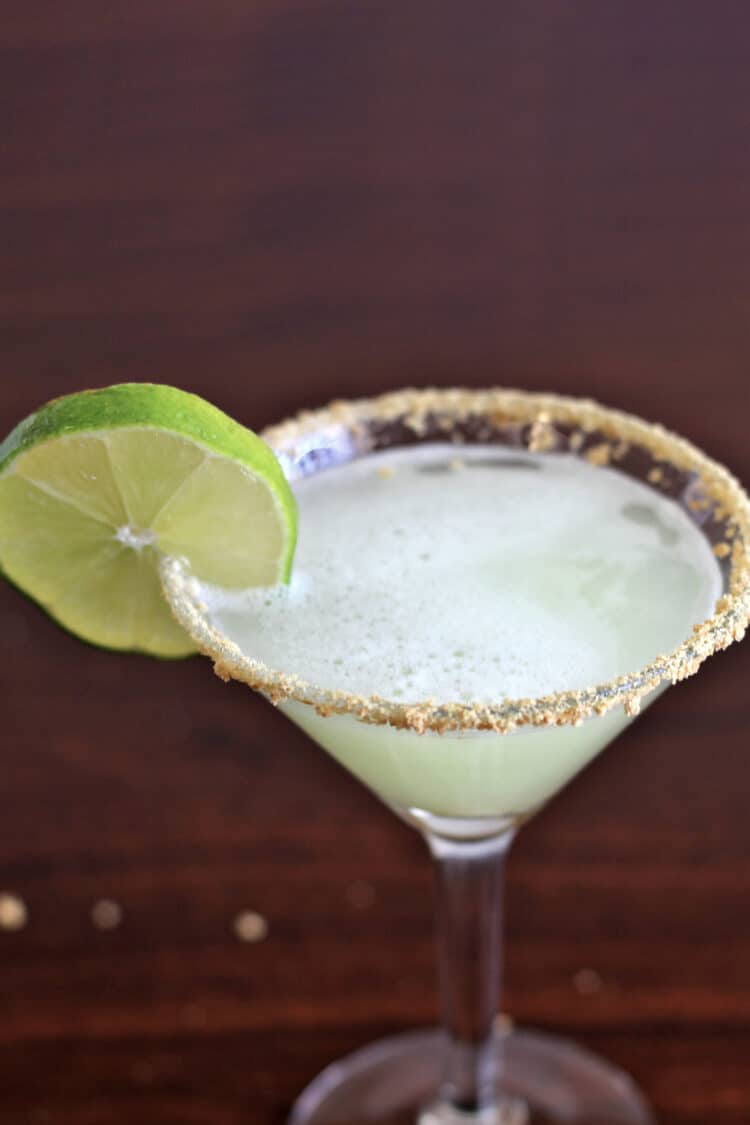 Key Lime Martini in glass with lime wheel and graham cracker crumb rim