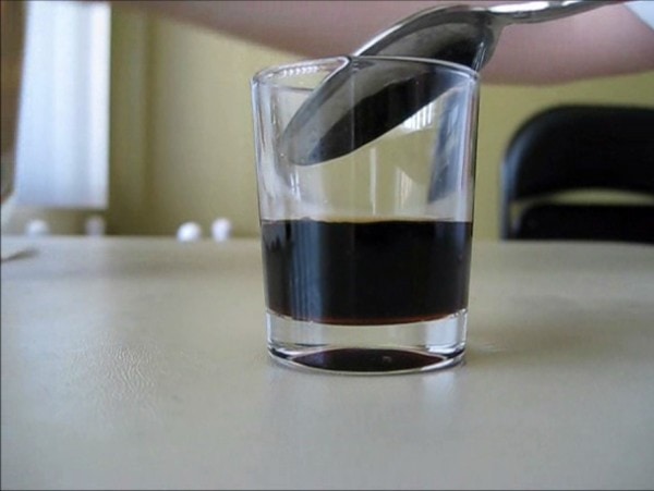 Pouring second layer of cocktail over back of spoon