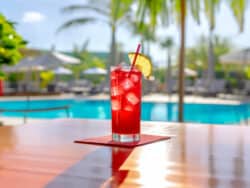 Long Beach Iced Tea cocktail on table in front of beach