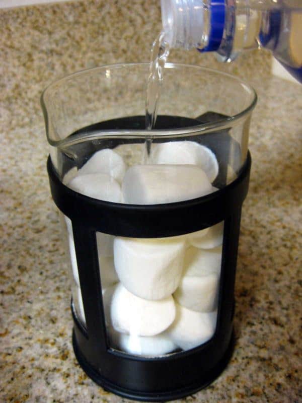 Pouring vodka over marshmallows in French press