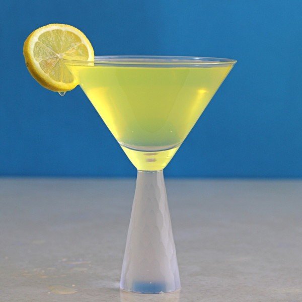 Milano Cocktail with lemon slice against blue background