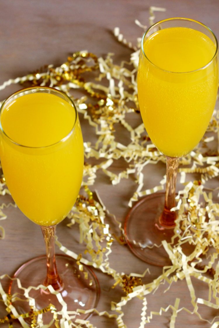 Mimosa cocktails on table with gold streamers