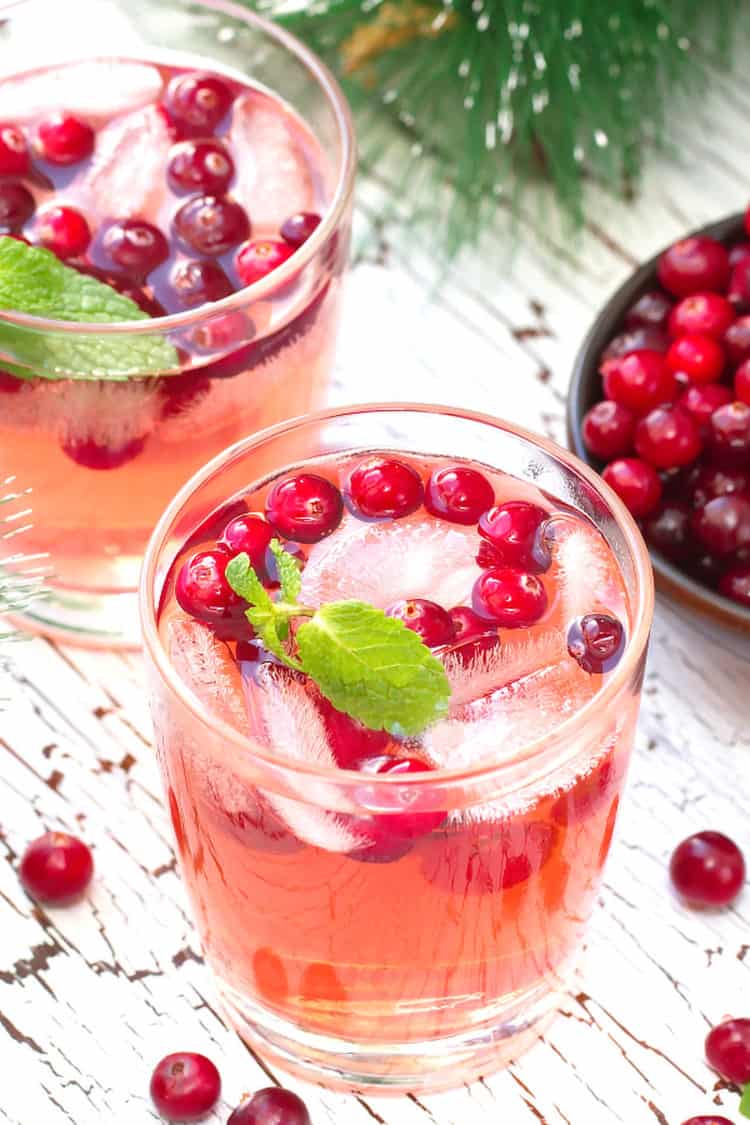 Pinkish Mistletoe Martinis cocktail with cranberries and mint leaves