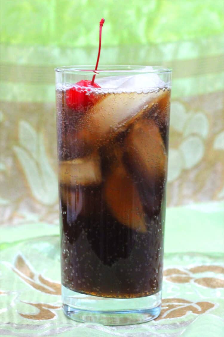 Mixy's Rum and Coke in tall glass with ice and cherry