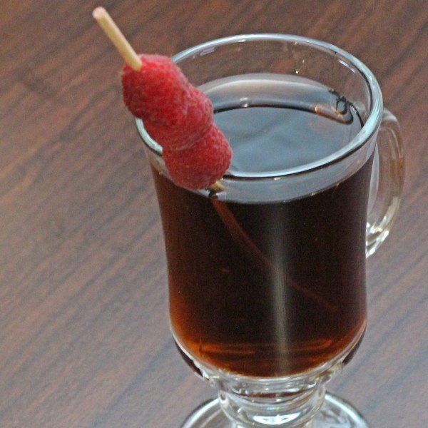 Closeup view of speared raspberry garnish on Mocha Berry drink 