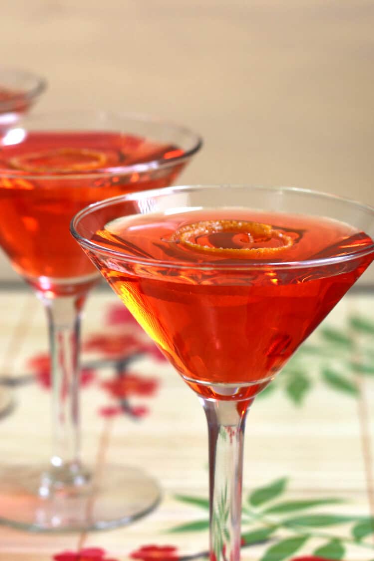 Bright red Negroni cocktails served on bamboo placemat
