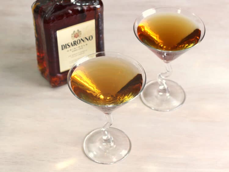 Overhead shot of two Nilla Wafer Martini drinks on a table with bottle of amaretto