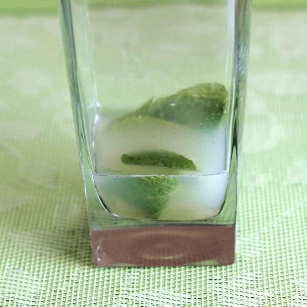Closeup of muddled lime at bottom of Nojito mocktail