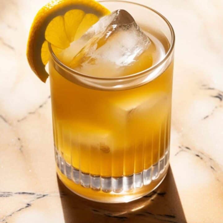Penicillin cocktail with lemon twist on table