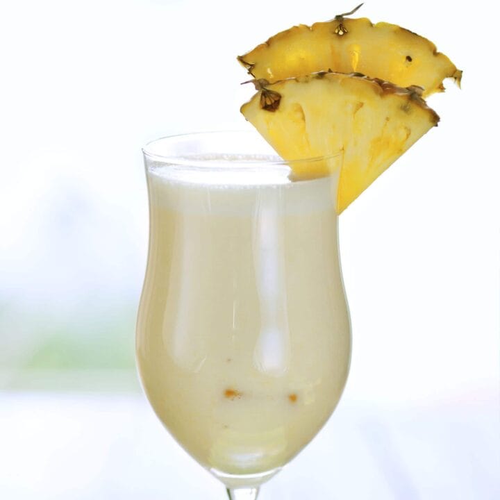 Pina Colada drink with pineapple wedges on table
