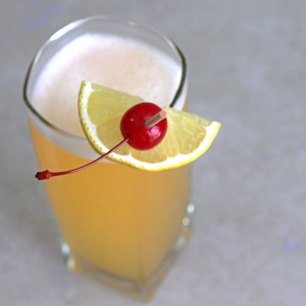 Angled view of Quantum Theory drink with cherry and lemon wedge