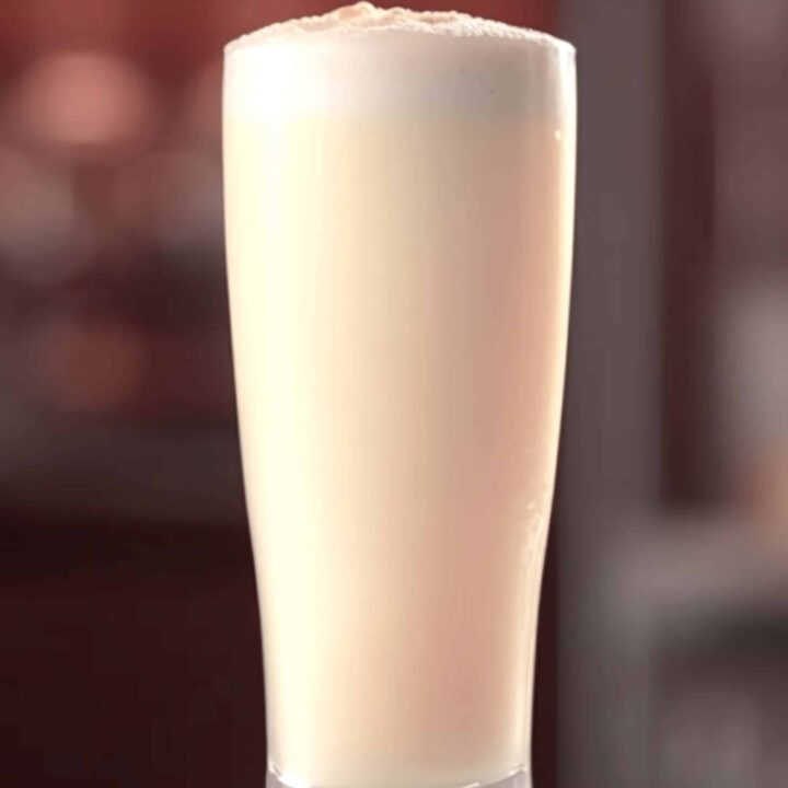 Ramos Gin Fizz cocktail in tall glass on bar